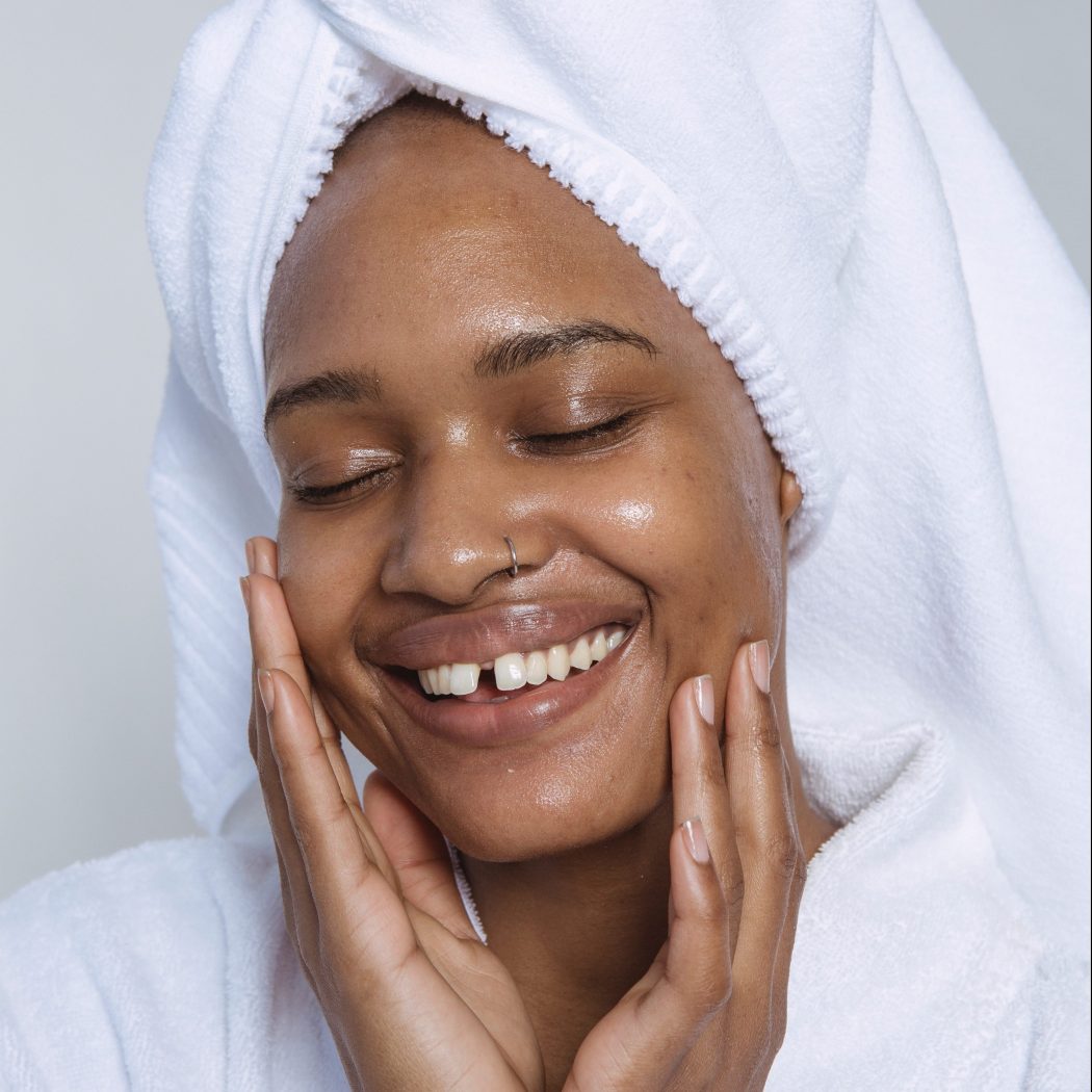smiling-black-woman-shows-benefits-of-facial-cleansing-oil