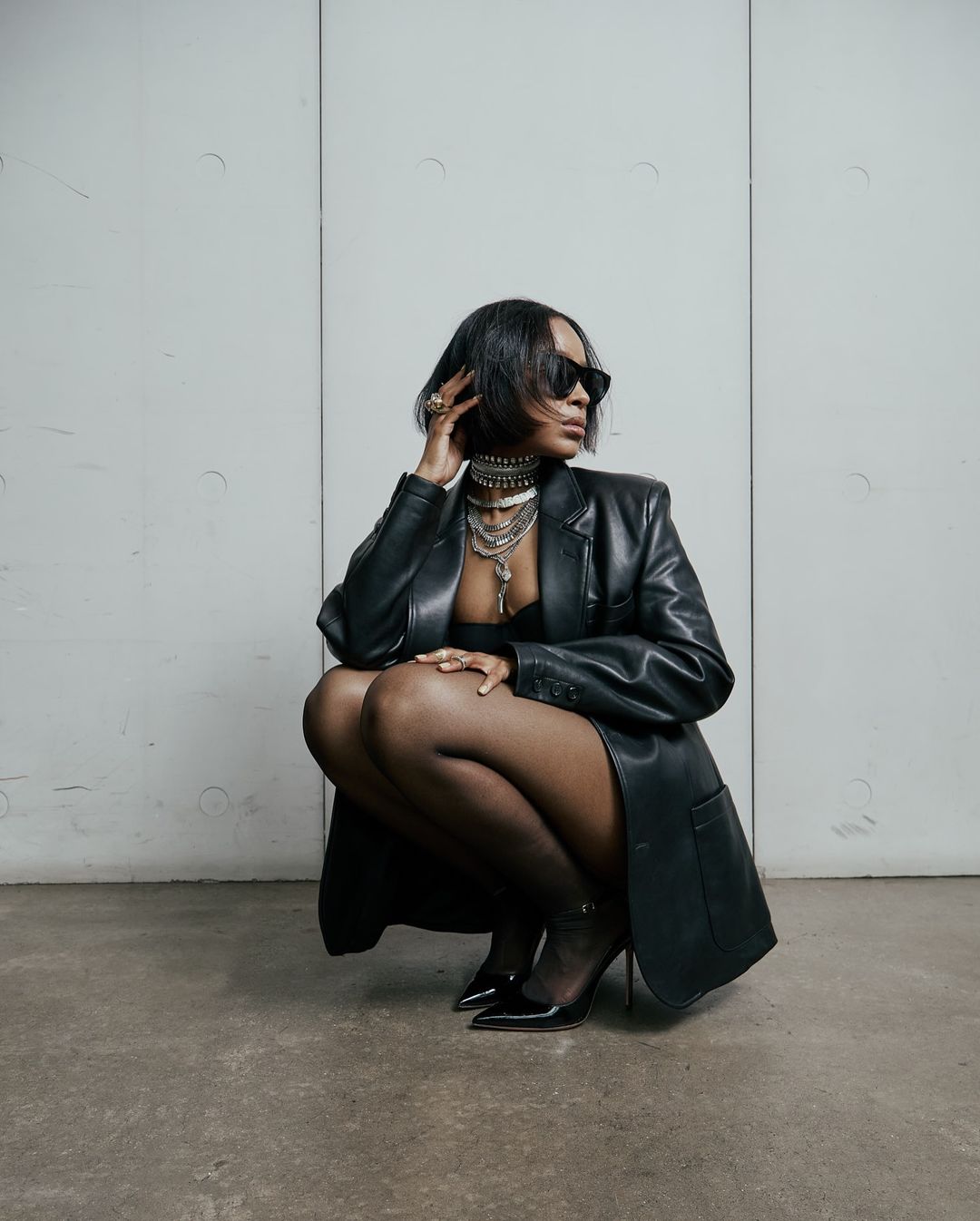 Woman wears a black leather outfit with statement necklace 