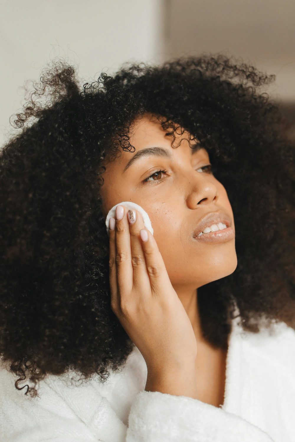 woman cleaning her face with cleansing oil for glowing skin