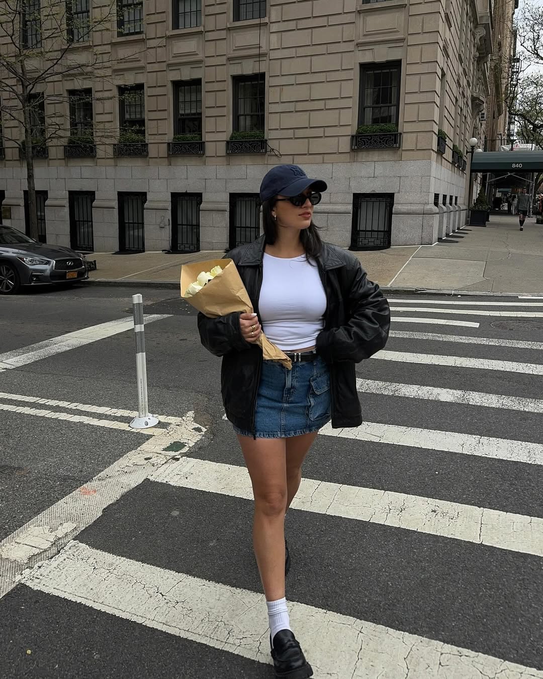 Woman wears a mini -freight skirt with white crop top and black jacket