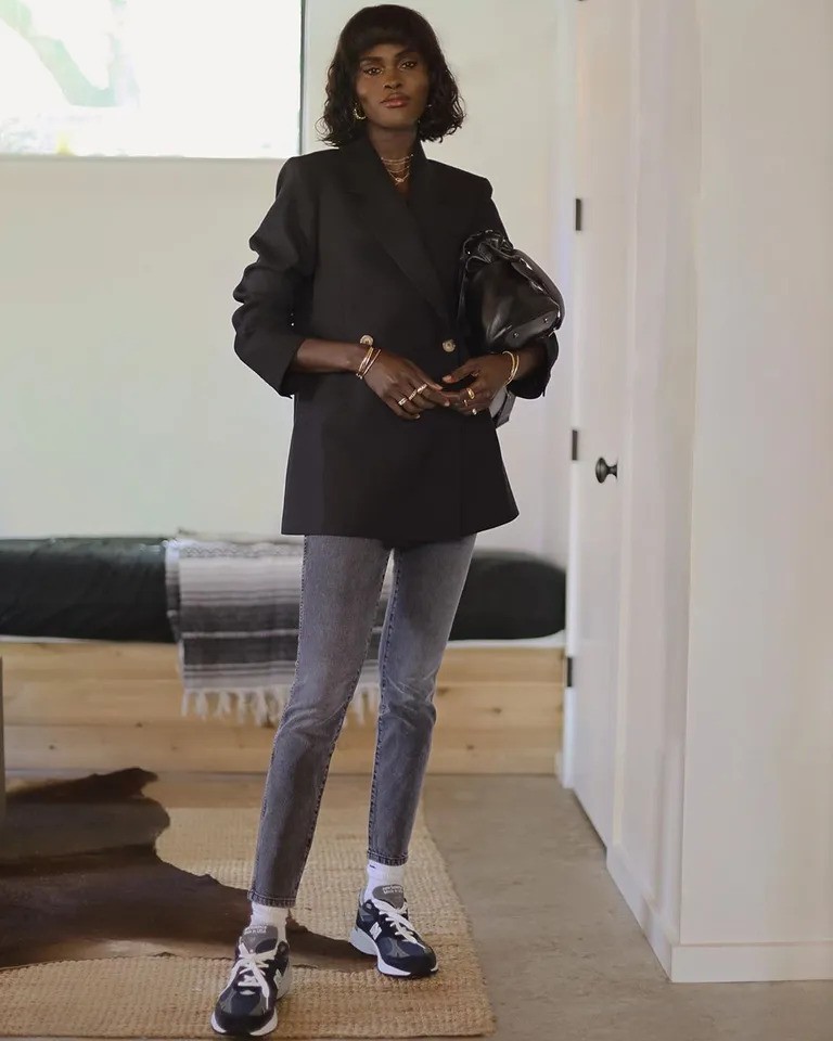 woman wearing skinny jeans with blazer and sneakers